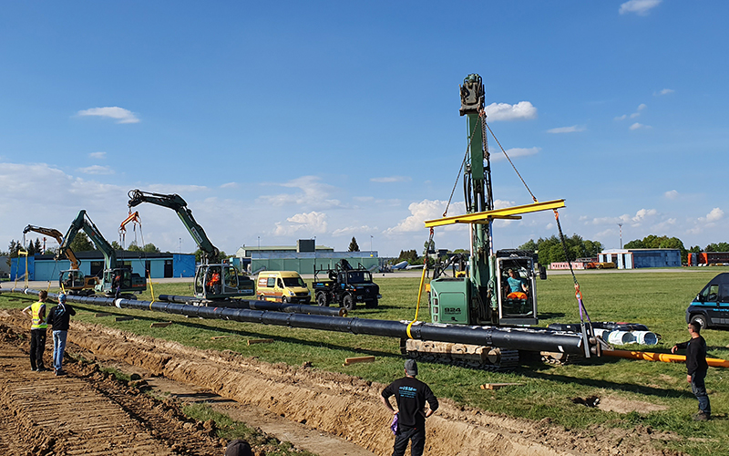 Excavation work for district heating grid. The image detail shows four excavators and multiple workers.